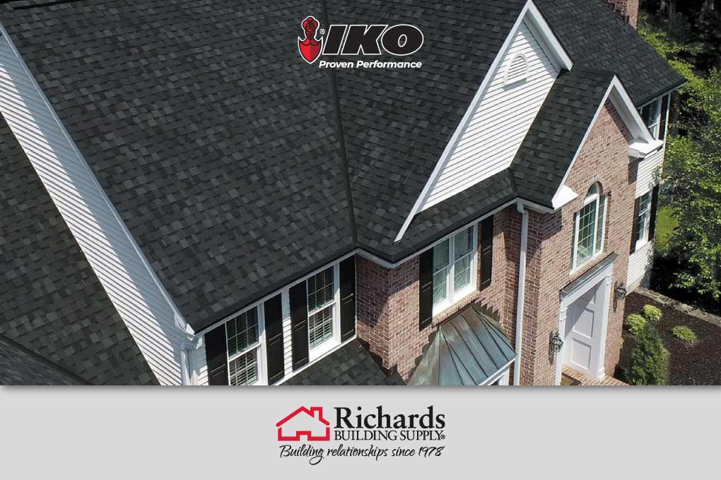 Roof of a 2 story brick house with black IKO Nordic shingles.